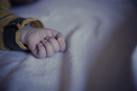 toddler's hand on white cloth thumbnail