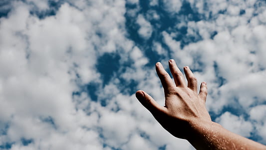 person raising hand under clouds thumbnail