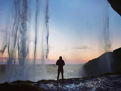 silhouette of person standing on cliff with water drops during sunset thumbnail