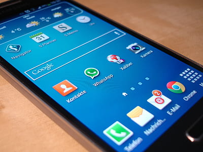 turned-on black Samsung Galaxy smartphone on brown surface thumbnail