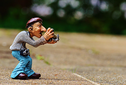 man holding camera figurine thumbnail