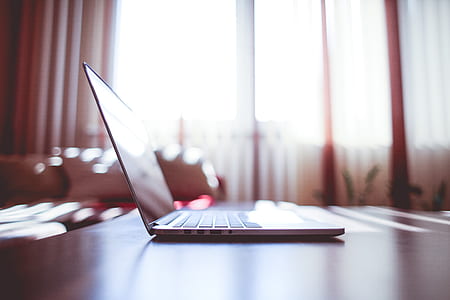 White Laptop Computer on Brown Wooden Table thumbnail