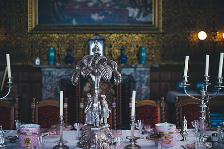gray candle holders with white candles on table inside room thumbnail