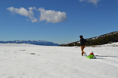 person holding brown rope walking on snow field during daytime thumbnail