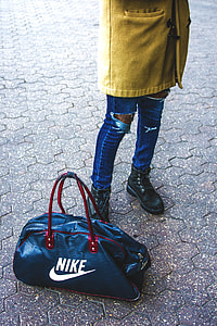 person standing beside black Nike duffel bag thumbnail
