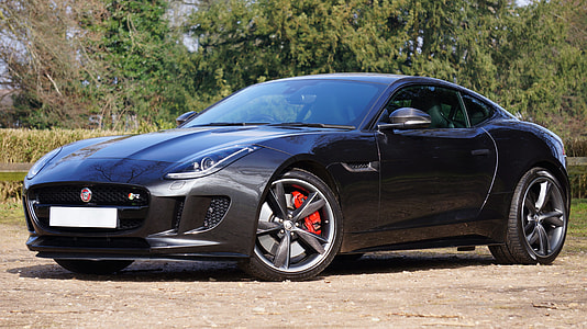 black Jaguar F-type coupe parked on dirt road near tree at daytime thumbnail