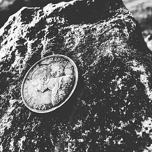 Grayscale Photo of Victoria Queen Coin on Top of Rock thumbnail