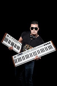 Man Wearing Black Crew-neck Shirt Holding White Keyboards thumbnail