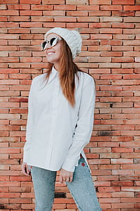 woman standing near bricked wall thumbnail