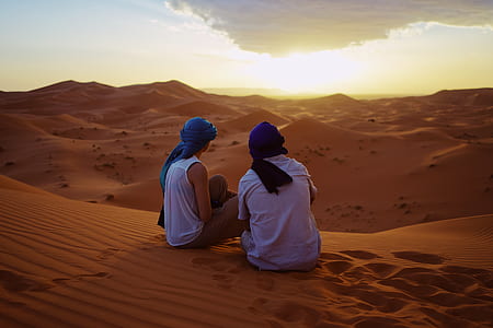 man and woman sitting on desert thumbnail