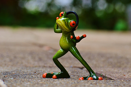 selective focus photography of red and green frog wearing headset figurine on brown surface thumbnail