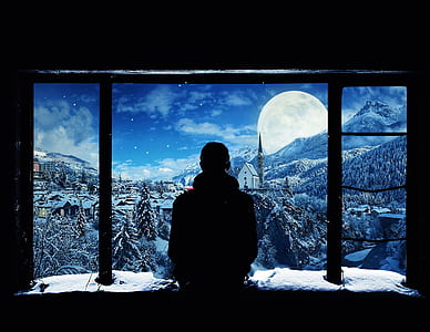 silhouette of man standing near window during snow time thumbnail