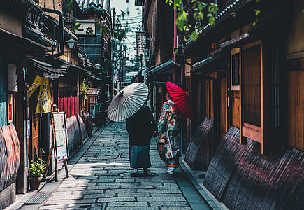 two person holding umbrellas standing on concrete pavement at daytime thumbnail