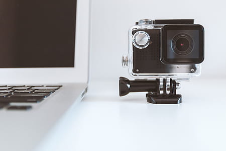 black action camera besides white laptop thumbnail