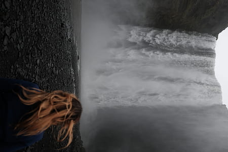 woman standing near waterfalls thumbnail
