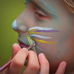 person doing face paint on person's face thumbnail