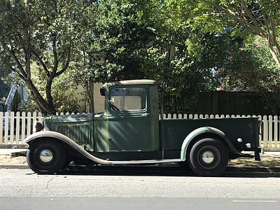 green single cab pickup truck on gray concrete road near green trees at daytime thumbnail