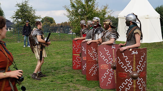 six men in metal armors with shields near white tent at daytime thumbnail