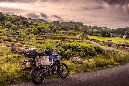 blue and black motorcycle at the road during daytime thumbnail