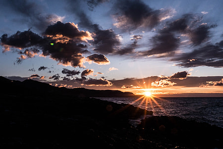 silhouette photo of body of water and mountains thumbnail