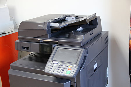 turned-off gray photocopier beside white painted wall thumbnail
