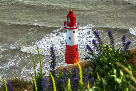 white and red lighthouse on body of water thumbnail