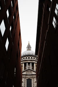 white and gray concrete dome in between concrete buildings thumbnail
