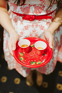 person holding red tray with paper cups thumbnail