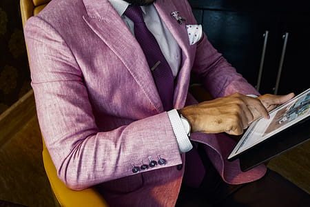 Man Wearing Pink Suit Jacket Holding Using Tablet Computer thumbnail