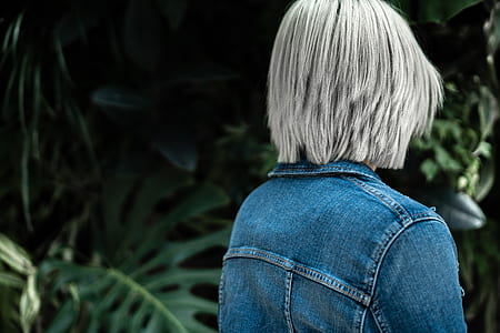 person facing green leafed plant wearing blue denim jacket thumbnail