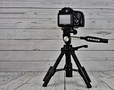 black camera with tripod stand near wall thumbnail