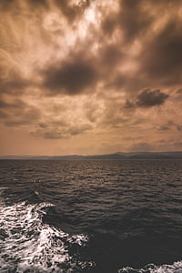 body of water under brown sky thumbnail