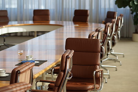 silver and brown leather padded rolling chairs in front of brown table thumbnail