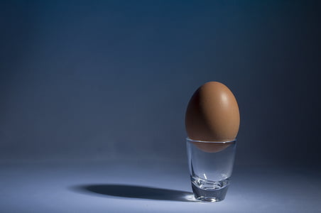 brown egg on top of clear shot glass thumbnail