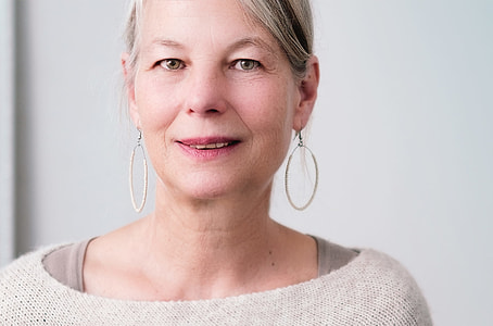 woman wearing pair of silver-colored hook earrings thumbnail