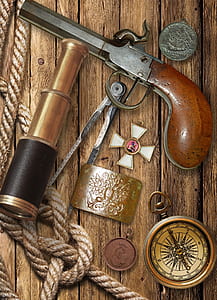 vintage pistol and gold spyglass on table thumbnail