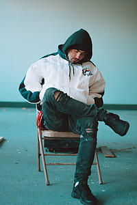 man sitting on chair beside wall thumbnail