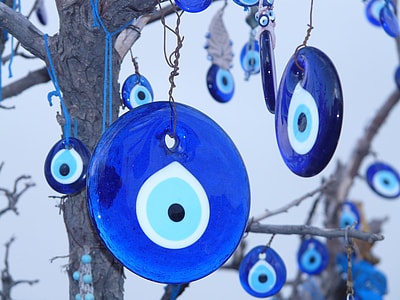 Evil's eye pendants hanged on tree at daytime thumbnail
