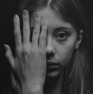 Grayscale Photo of Woman Covering Her Face by Her Hand thumbnail