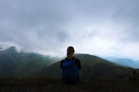woman wearing backpack looking at mountains thumbnail