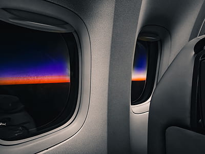 person sitting inside aircraft near window thumbnail