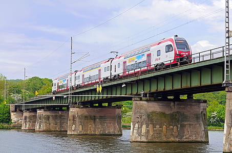 white and red train beside body of water thumbnail
