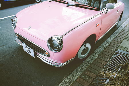 pink car parked on side of road thumbnail