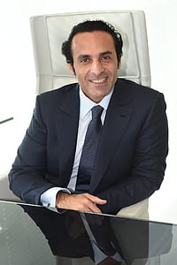 man wearing black formal coat smiling in front of camera thumbnail