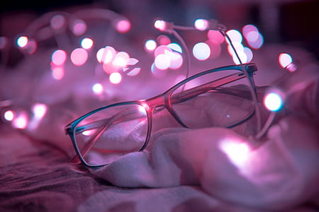 Shallow Focus Photography of Blue-framed Eyeglasses Near String Lights thumbnail