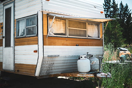 two gray gas cylinders beside white and brown travel trailer thumbnail