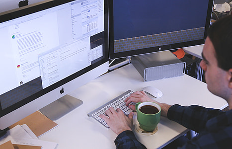 person in black long-sleeved shirt in front of silver iMac using Apple Magic Keyboard thumbnail