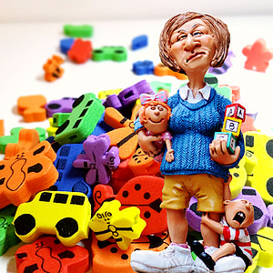 woman carrying baby beside child figurine near assorted-color foam toys thumbnail