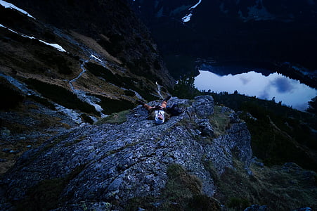 man lying on gray stone mountain thumbnail