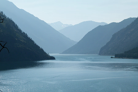 calm of body of water surrounded by mountains thumbnail